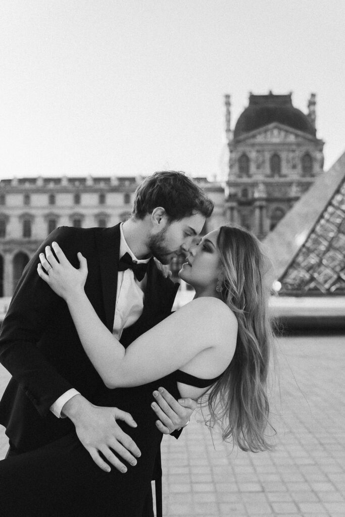 Couple enlacé devant le pyramide du Louvre- photographe mariage Julie Chef Photography