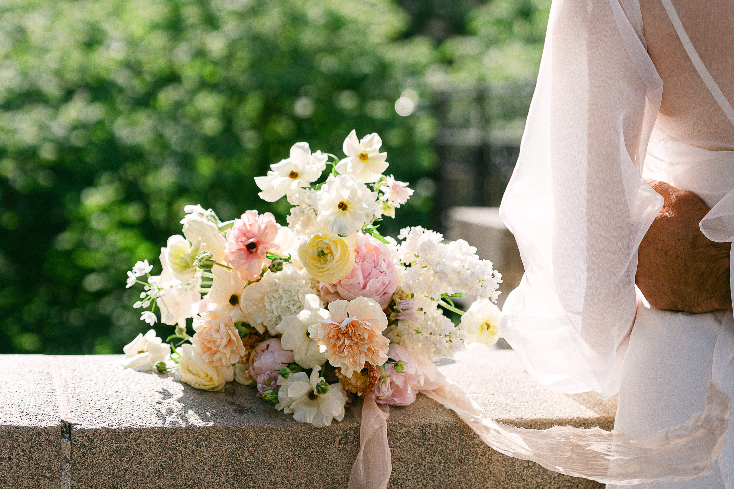 bridal bouquet placed on a low wall on Avenue de Camoens