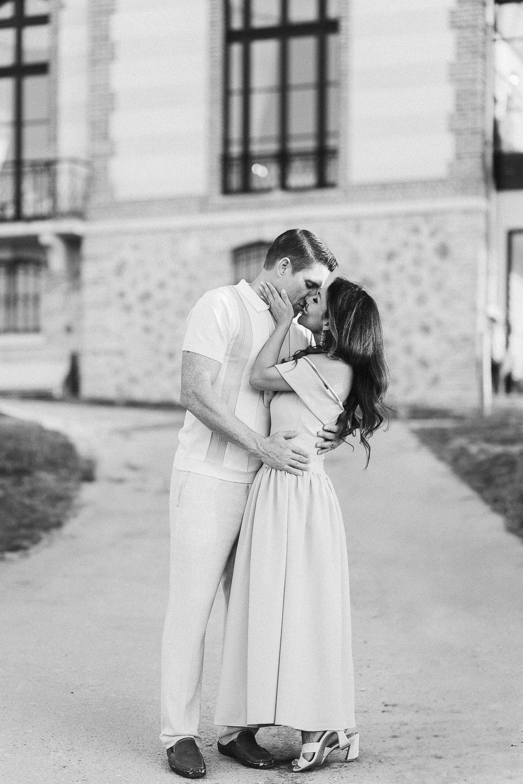 Elegant American couple kissing in front of Château de Sacy, romantic moment in Champagne