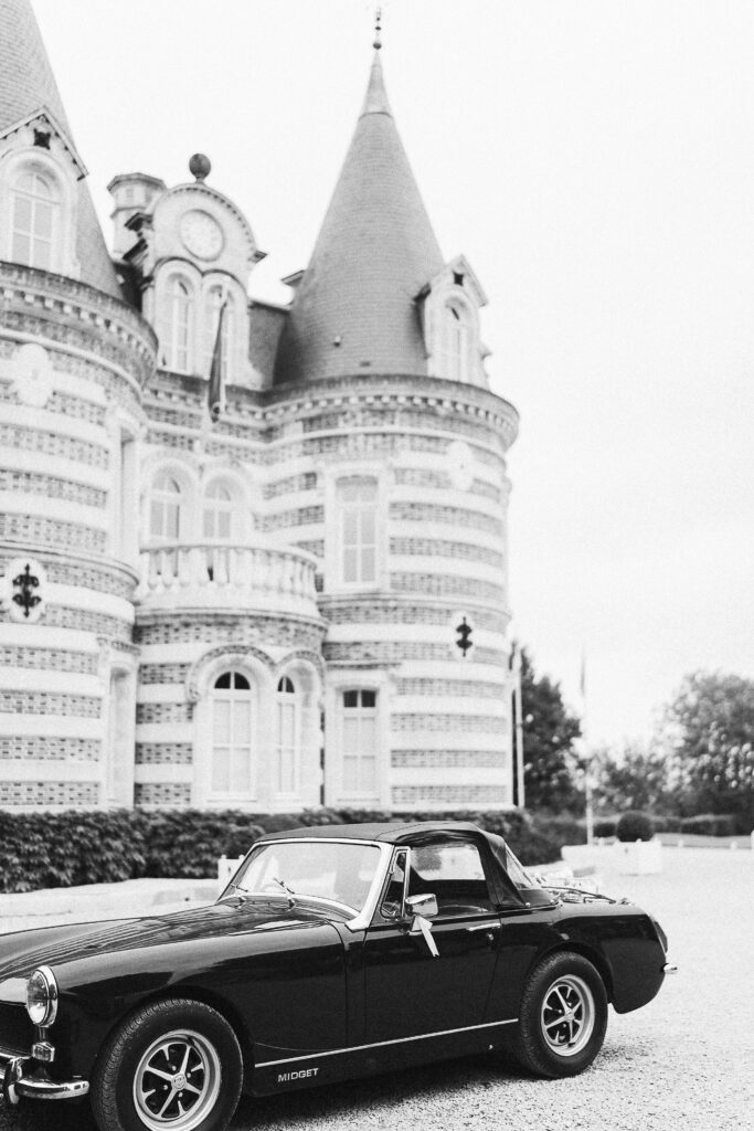 A vintage car for a wedding parked in front of Countess Lafond's castle